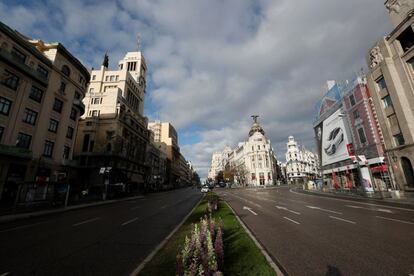 Vista de la calle de Alcalá, casi vacía de tráfico esta mañana de Viernes Santo y con muy pocos transeúntes por sus aceras.