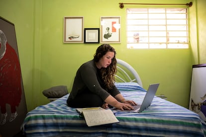 Elaine Vilar Madruga, escribiendo sobre una cama.