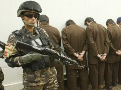 Agentes de seguridad afganos vigilan a cinco sospechosos en Herat.
