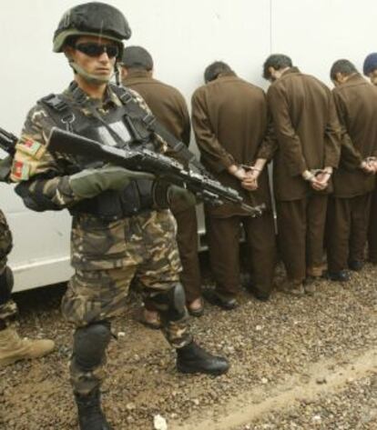 Agentes de seguridad afganos vigilan a cinco sospechosos en Herat.