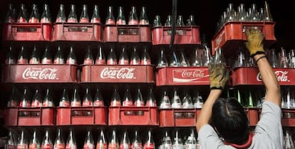 Um trabalhador empilha caixas de garrafas de Coca-Cola, no México.