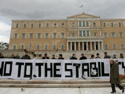 Activistas sostienen una gran pancarta en la que se lee "no al pacto de estabilidad" delante del Parlamento griego en Atenas.