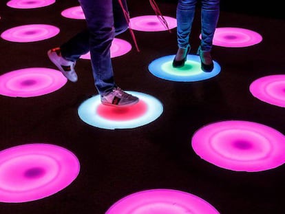 Dos personas recorren una instalación de arte con luces LED durante la presentación de una experiencia interactiva Pop-art 'Luces y Arte' en Kuala Lumpur, Malasia.