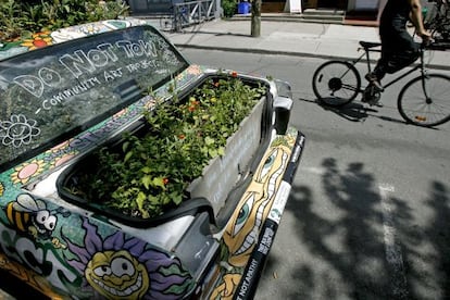 Un coche convertido en pieza de arte callejero decorado con plantas en el distrito de Kensington, en Toronto (Canadá).