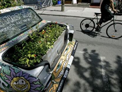 Un coche convertido en pieza de arte callejero decorado con plantas en el distrito de Kensington, en Toronto (Canadá).