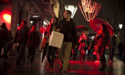 Los paseantes disfrutan de la Shopping Night en Barcelona.