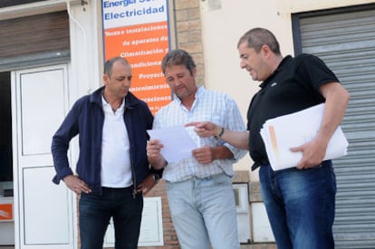 El empresario Juan Manuel Garrido, a la derecha, junto a dos vecinos que han entregado la documentación para la oferta de trabajo en Emiratos Árabes.