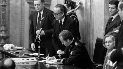 El rey Juan Carlos I firma la Constitución en el Congreso ante el presidente de la Cortes Españolas, el presidente del Congreso y la reina Sofía.