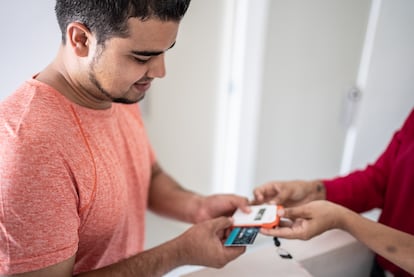 joven paga con tarjeta de crédito en un hotel.