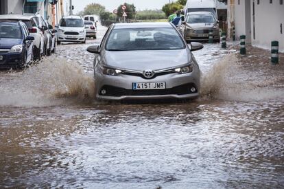 Un coche atraviesa una calle inundada en Valencia.