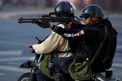 Un policía antidisturbio apunta a unos manifestantes con su arma durante una protesta contra Nicolás Maduro, en Caracas, el 26 de junio de 2017.
