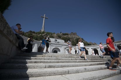 Turistas visitan en el Valle de los Caídos con la cruz de fondo.