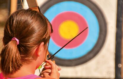 Una niña practica el tiro con arco en un campamento de Eix Est Els, en Cataluña.