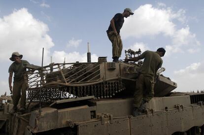 Soldados israelíes realizan labores de mantenimiento en un taque en una nueva posición a pocos kilómetros de la frontera de Gaza con Israel.