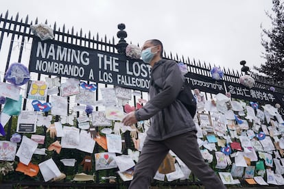 Un hombre pasa ante una verja con mensajes por la memoria de los fallecidos en Nueva York.