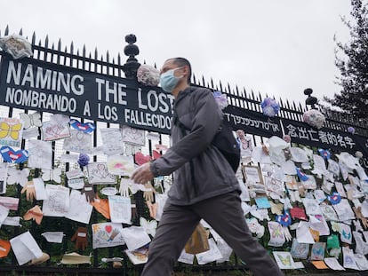 Un hombre pasa ante una verja con mensajes por la memoria de los fallecidos en Nueva York.