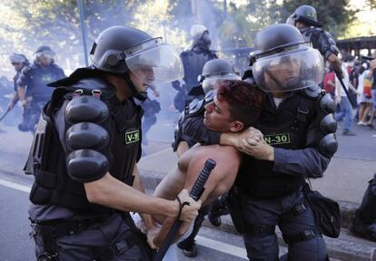 Policiais detêm manifestante em protesto no dia da final da Copa, no Rio.