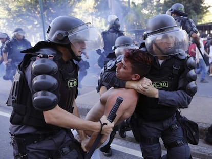 Policiais detêm um manifestante neste domingo, no Rio.