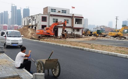 Una casa de tres pisos se encuentra en la calle central del distrito de Luolong, lo que obliga a detener la construcción de una carretera, el 16 de mayo de 2015 en la provincia de Henan, China.