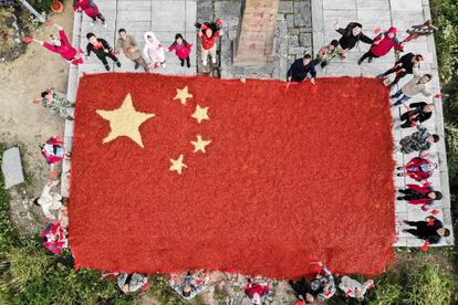 Agricultores posan con la bandera nacional de China hecha con chiles y maíz en la ciudad de Longquan, el 26 de septiembre de 2017.