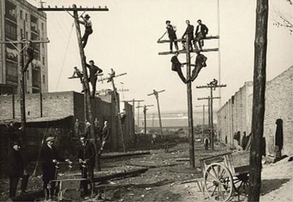 La escuela de celadores de Barcelona, en plena clase práctica para tender los hilos telefónicos en 1925.
