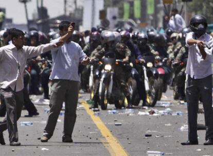 Miembros de una milicia progubernamental reprimen la manifestación de protesta de los opositores ayer en Teherán.