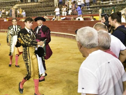 Varea, torero valenciano, tijera en mano, pide a uno de sus colaborares que le corte la coleta.