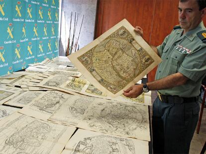 Un guardia civil muestra ayer uno de los mapas confiscados.