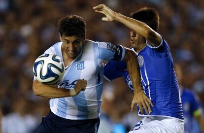 Diego Milito pelea un bal&oacute;n con Rolando Garc&iacute;a 