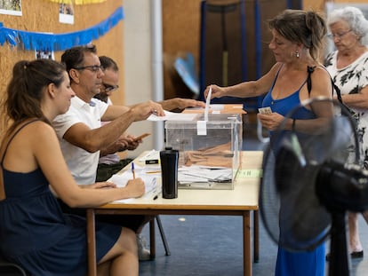 Una mujer vota en un colegio electoral de Barcelona equipado con múltiples ventiladores, este domingo.