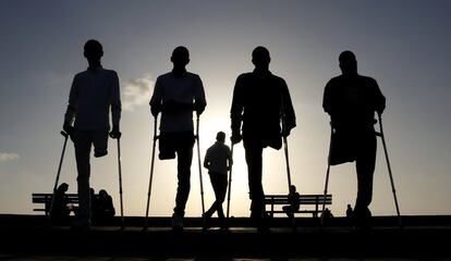 Cuatro amigos palestinos que fueron heridos durante conflictos pasean por la costa de Gaza el 24 de octubre de 2016.