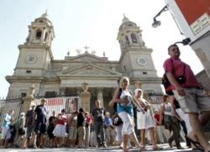 Un grupo de turistas pasa por delante de la fachada de la catedral de Pamplona.