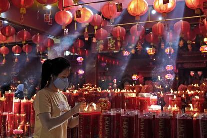 Una mujer enciende una vela durante sus oraciones como parte del Año Nuevo Lunar, en el templo Hok Lay Kiong en Bekasi (Indonesia). Durante esta celebración se reza a los ancestros y se pide abundancia y fortuna para el año entrante.