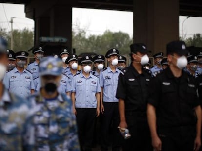 Soldados e policiais chineses participam de homenagem às vítimas na terça.