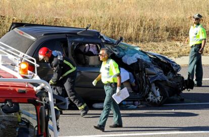 Guardias civiles y bomberos inspeccionan uno de los vehículos siniestrado en la colisión frontal entre dos turismos en Carrascal de Barregas (Salamanca), en la carretera A-62.
