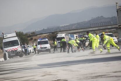 Operarios limpian el gasoil derramado por un cami&oacute;n cisterna.