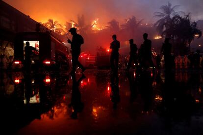 Oficiales de policía hacen guardia durante un incendio en el hotel Kandawgyi Palace en Myanmar, el 19 de octubre de 2017.