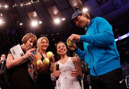 Nadal firma pelotas a tres aficionadas.