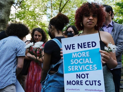 Una manifestante con un cartel que dice "Necesitamos más servicios sociales, no más recortes", este miércoles en Nueva York.