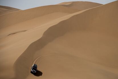 Un automovil de rally se aleja de una duna durante un ejercicio de mapeo el desierto de Gobi, al noroeste de Pekín (China).