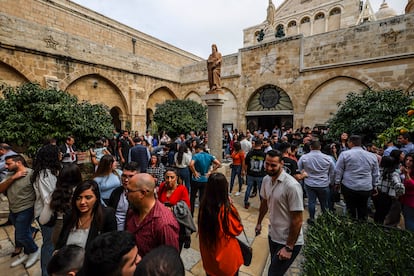 Salida de la misa en la Basílica de la Natividad de Belén. Tras más de veinte años nadie repara enel disparo en la espalda de la estatua de San Jerónimo, recuerdo de la Segunda Intifada, que preside la entrada de la Basílica.