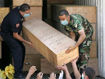 Un soldado y un miembro de protección civil trasladan el ataúd de una víctima civil de los bombardeos israelíes sobre la ciudad libanesa de Tiro.