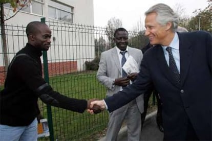 El primer ministro francés, Dominique de Villepin, saluda a un joven de Aulnay-sous-Bois, en la región de París.