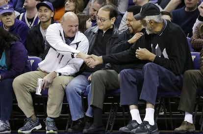 Steve Ballmer, de blanco, saluda a la exestrella de la NBA Bill Russell durante un partido de la liga estudiantil en 2005.