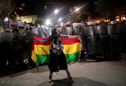 Una manifestante en contra del Gobierno de Evo Morales es rodeada por agentes de la policía, la noche del lunes, en La Paz.