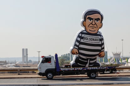 Un muñeco de Bolsonaro con uniforme de presidiario, paseado por estudiantes este viernes en Brasilia, con el Congreso al fondo. 