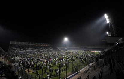 El público invade el campo de juego tras los disturbios de este jueves por la noche durante un partido entre Gimnasia y Boca Juniors en la ciudad de La Plata, Argentina.