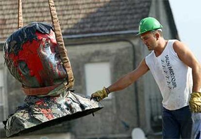 Un trabajador procede a retirar el busto de Franco de la Plaza Mayor de la localidad pontevedresa de Ponteareas.