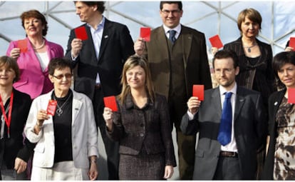 Bibiana Aído, en el centro, ayer, con las ministras de Igualdad belga y húngara, entre otros, todos con tarjetas rojas contra el maltrato a las mujeres.