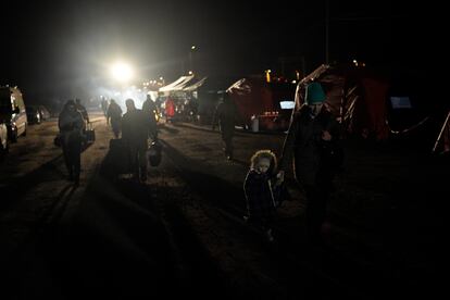 Refugiados que huyen de la guerra en  Ucrania caminan hacia un tren en el cruce fronterizo de Medyka, Polonia, el jueves 10 de marzo de 2022.